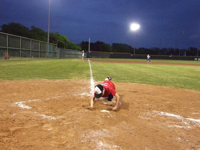 Image: Slidin’ in — This young man took a nose dive for home plate.