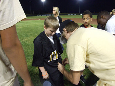 Image: Vintage varsity — Varsity player, Colten Campbell, was obliged to help this young man with his new jersey.