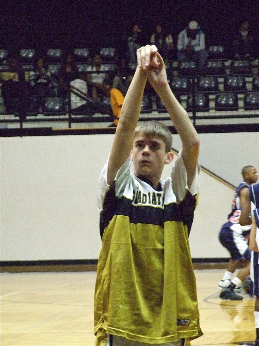 Image: Justin loosens up — 8th grader Justin Wood practices his free throw shooting before his team’s game against Red Oak Life.