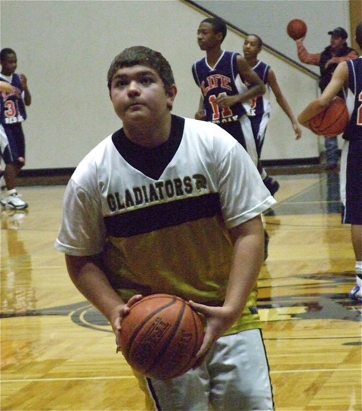 Image: Kevin practices — 8th grader Kevin Roldan gets warmed up before the game.