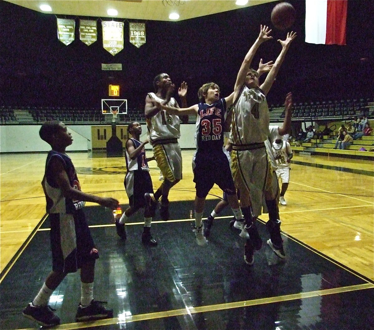 Image: Wood gets up — Justin Wood(4) controls the boards with help from Trevon Robertson(15).