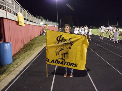 Image: Karen holds new flag — Nice and clean-the old gold never looked better. Karen Mathiowetz brings the flag for each game.