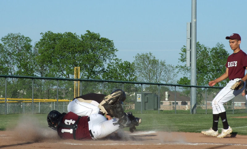 Image: A little bit of dust flying — Brandon Souder and a Waxahachie Eagle toss a little sand at home plate on Friday.  Souder was running to home when the catcher tried to tag.  Italy gained the point.