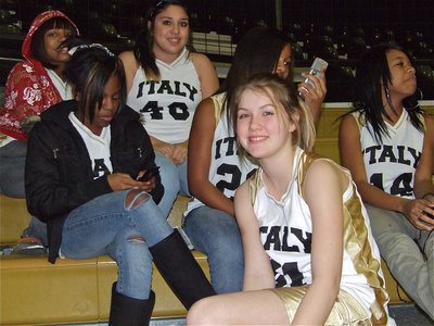 Image: 8th grade girls — Ashley Harper(under the hood), Kendra Copeland(on the phone), Monserrat Figueroa(40), Bernice Hailey(22), Ryisha Copeland(14) and Taylor Turner(31) relax during the 7th grade game.