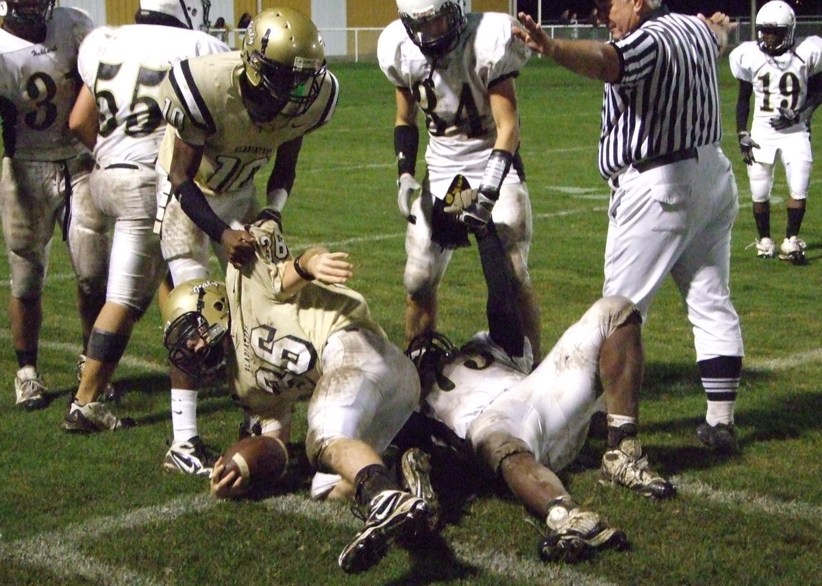 Image: Gladiators get a lift from John Isaac(10) and Justin Hayes(36) — John Isaac(10) separates Justin Hayes(36) from the pile as the Gladiators try to separate themselves from the other teams moving to 3-0 in district play, 4-2 overall.