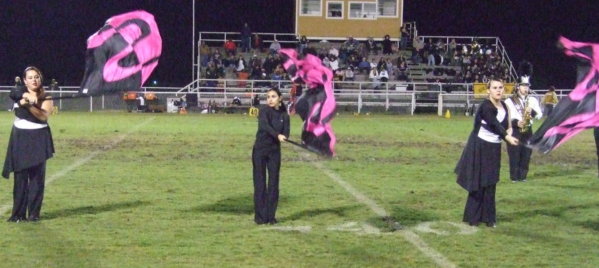 Image: IHS Flag Corp — The Gladiator Regiment Band’s Flag Corp performs during the halftime show.