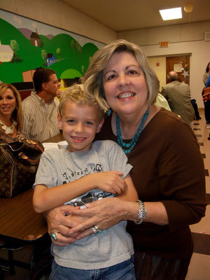 Image: Ann Hyles and grandson — Anne Hyles said, “When I think of Gorge Scott I think of what he gave to this school and to this town. His dream was that every kid that graduated from Italy High School would be able to get a college degree. He got the scholarship started so this could happen and he started it with is own money. He truly gave his life for this school.”