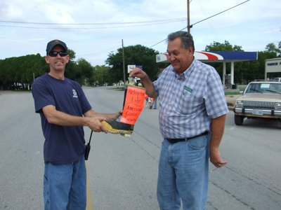 Image: Byrne gets the boot — Larry Byrne (Italy Relay for Life team member) helps “Fill the Boot” held by Tommy Sutherland.