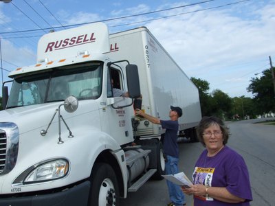 Image: The truck stops here — Even the big trucks stop to help with the cause. Tommy Sutherland holds the boot up for the driver, while Karen Mathiowetz looks down the road.