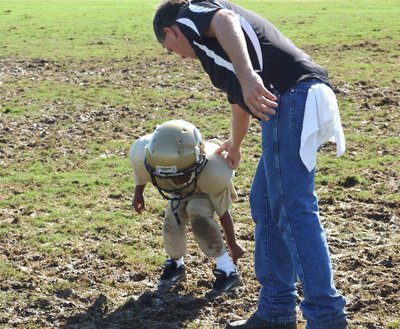 Image: Getting a tow — Somebody call Helm’s Garage…little Joe Jackson is stuck in the muddy tundra of Willis Field. Coach Wood fills in as tow line to get Joe out of his predicament.