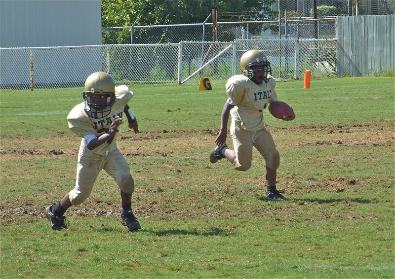 Image: This way! — Kendrick Norwood(1) sweeps left to make it difficult for the Lions to stalk him as Taron Smith(21) leads the way.