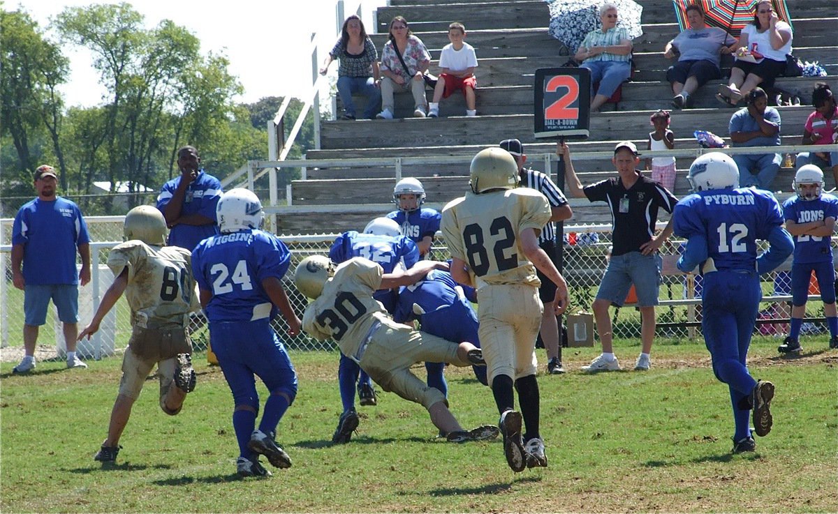 Image: When Gladiators attack — The IYAA Gladiators A-team defense led by Joseph Celis(30) stalk the Lions from behind.