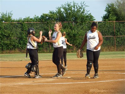 Image: Glove five — Catcher Mary Tate, pitcher Jaclynn Lewis, shortstop Bailey Eubank and first baseman Sa’Kendra Norwood keep each other pumped up after getting an out against Itasca.