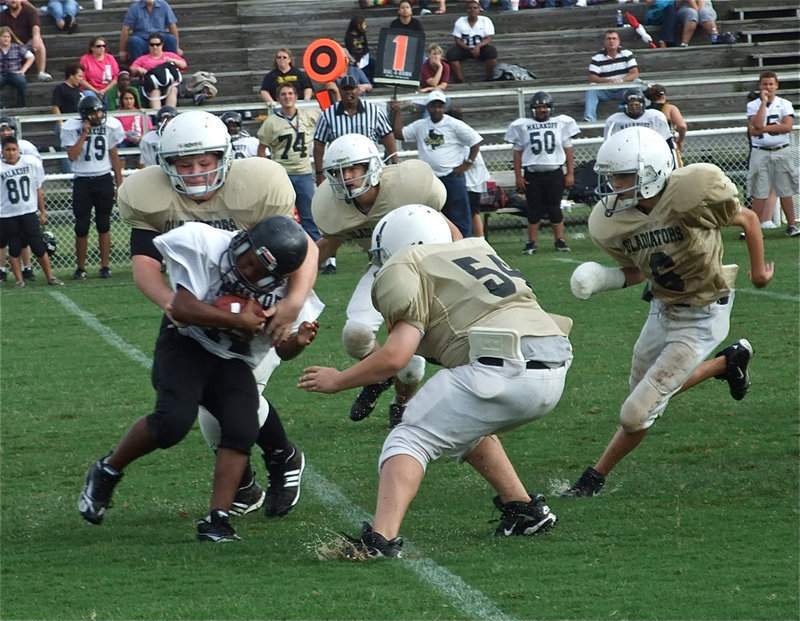 Image: Crunch! — Tyler VinCell crunches a Tiger runner with Jackson, Byers and Petry flying in for support.