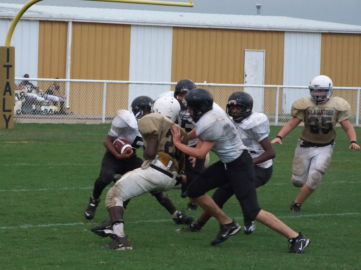 Image: 1 against 4 — Name Withheld (20) takes on a pack of Tigers as he tries to keep the Malakoff runner from reaching the sideline.