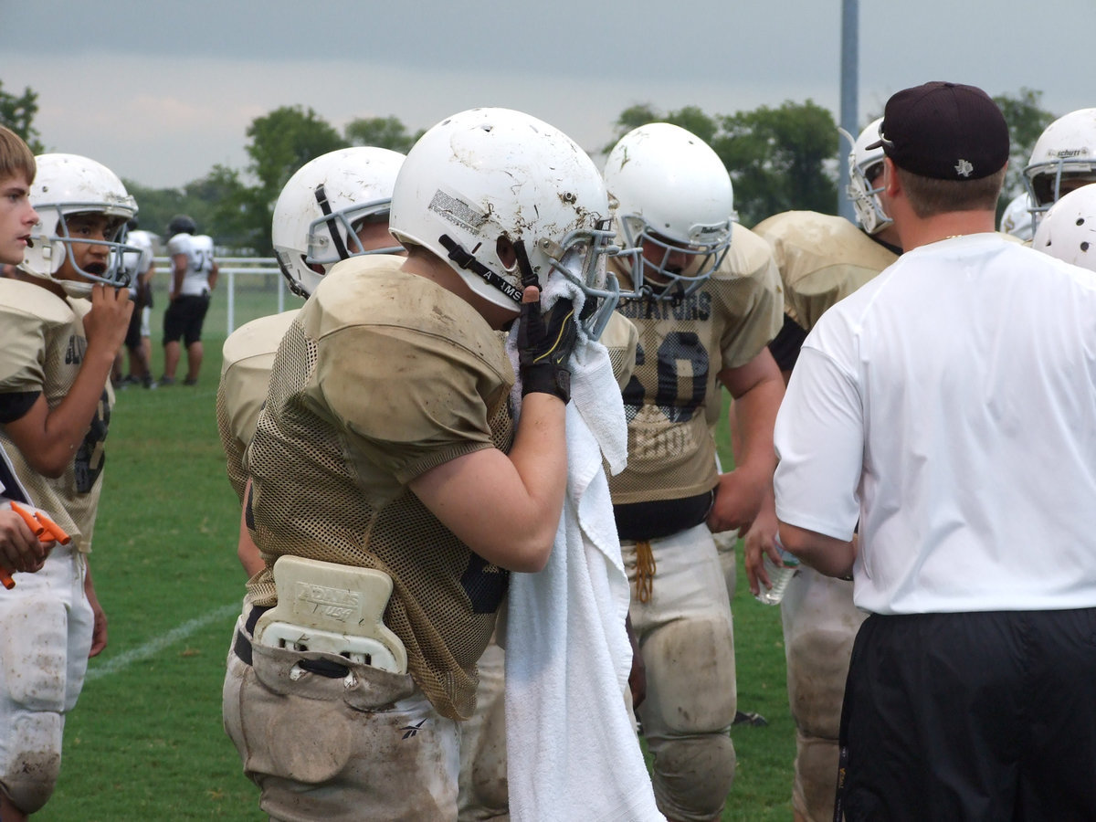 Image: Here’s mud in your eye — Tristin Smithwick tries to remove debri from under his facemask during a much needed break.