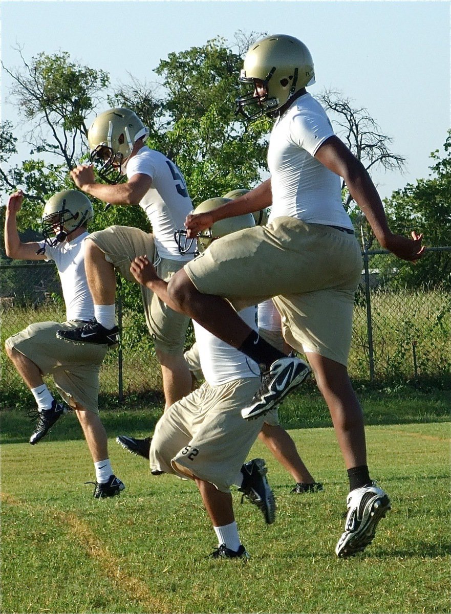 Image: Getting going — The lineman do a few excercises before running drills.