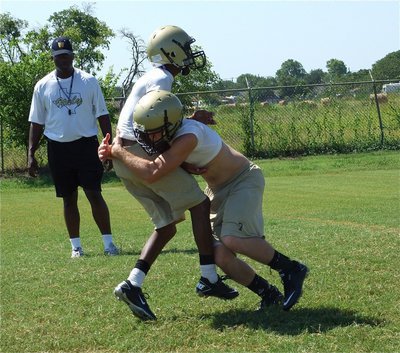 Image: That’s the way! — Kyle WIlkins(7) shows how it’s done during a form tackling session with Coach Erik Wilson.
