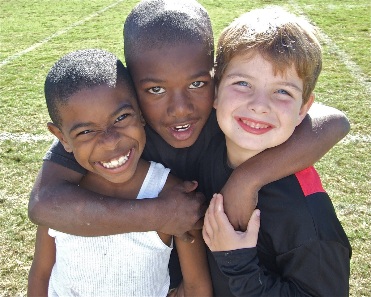 Image: Tyvon, Ricky and Gage — Teammates Tyvon Gates, Ricky Pendleton and Gage Wafer embrace after their IYAA C-Team picked up its fifth win of the season over Hubbard, 28-0. The C-Team is now 5-0 and has posted shutouts in all of their games.