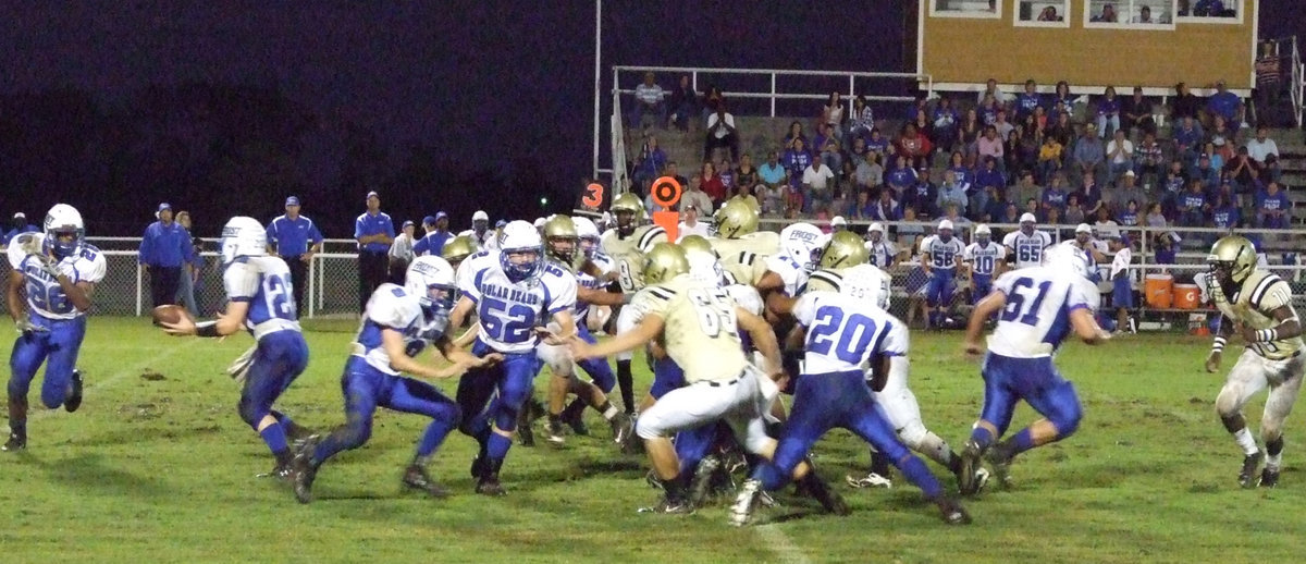 Image: Handoff — Defensive end Jonathan Nash(65) tries to slow down the Polar Bear sweep as linebacker Jasenio Anderson(11) pursues the play.