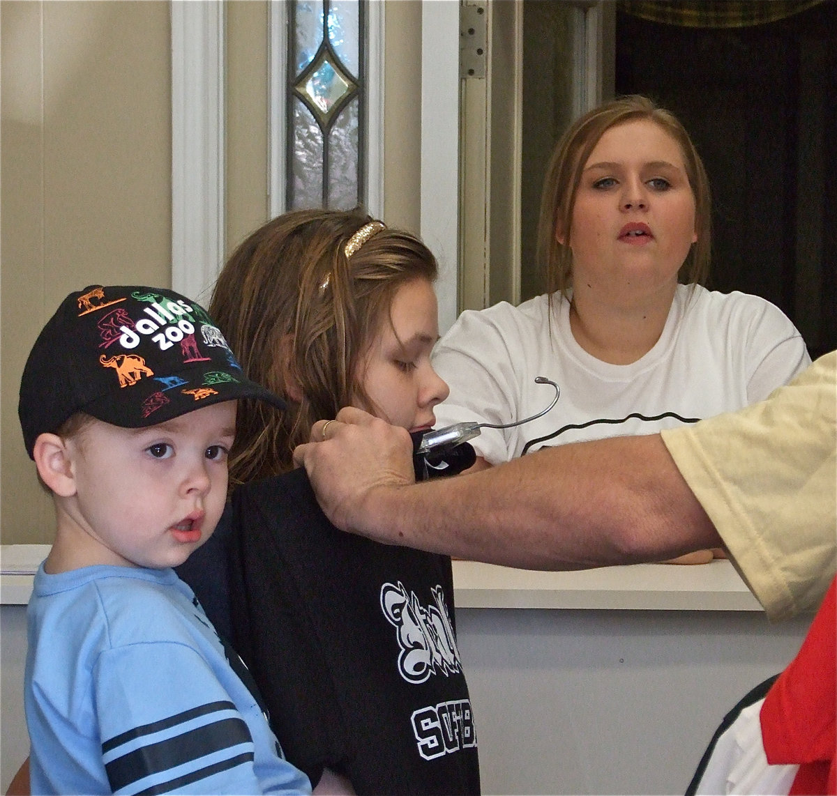 Image: Try this one — Gared Wood and Julia McDaniel help Lilly Perry get fitted for a shirt.