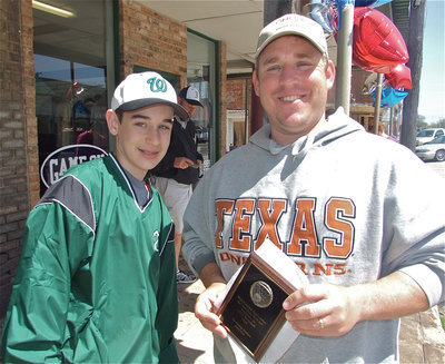 Image: Ryan and Scott — Ryan and his dad, Scott Connor, stop by the Game On Athletics apparel print shop’s grand opening to receive their IYAA Basketball trophy and coaches plaque. Scott is also the brother of Shelly Thompson, one of the Game On Athletics owners.