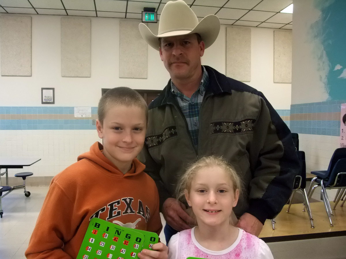 Image: Riddle Family — Courtney Riddle, (2nd grader), Clay Riddle (4th grader), and Curtis Riddle are ready to play a good game of bingo.