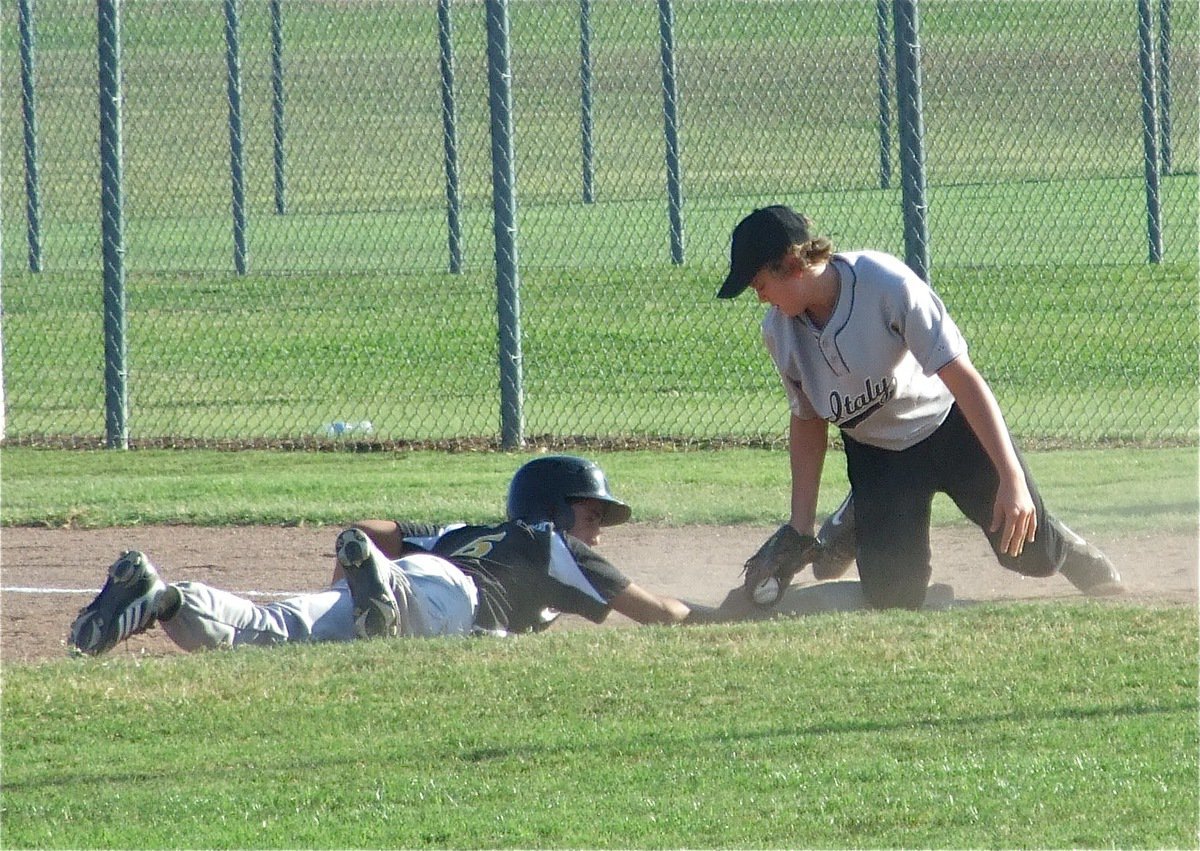 Image: Almost got him — Bailey Walton stirs up dust trying to get the runner out on first base.