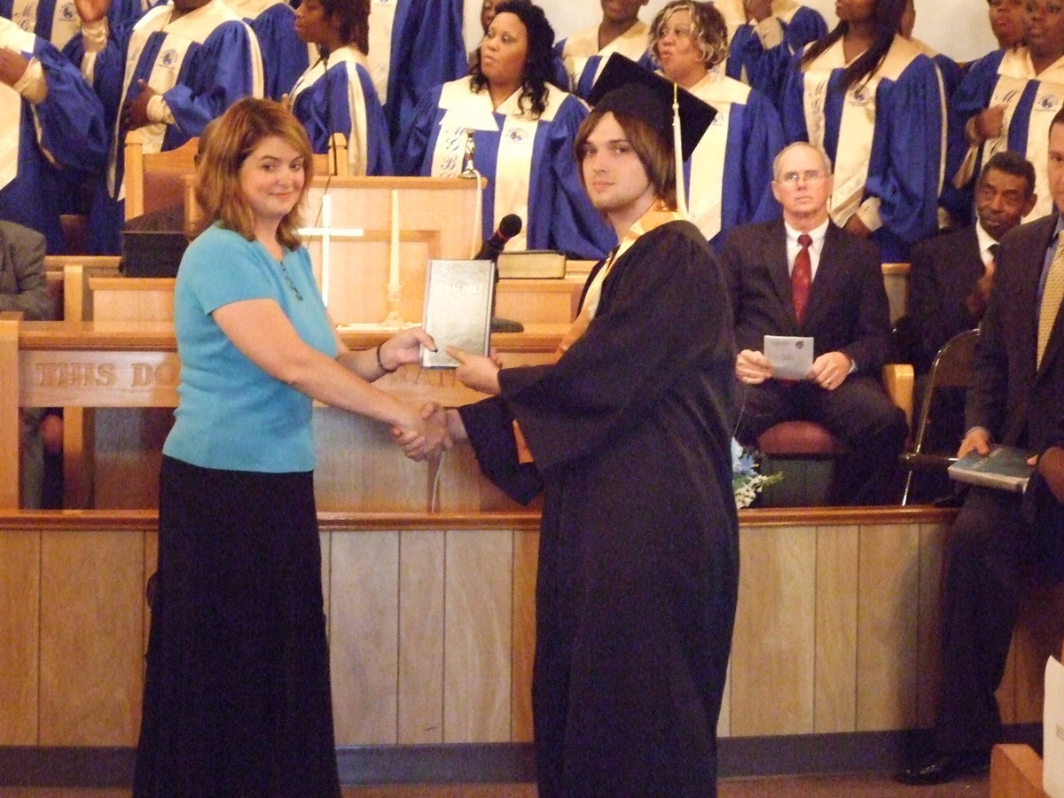 Image: Ms. Parker makes presentation — IHS Senior, Jeremy Worsham, receives a bible inscribed by the Italy Ministerial Alliance at the Baccalaureate Service on Sunday.