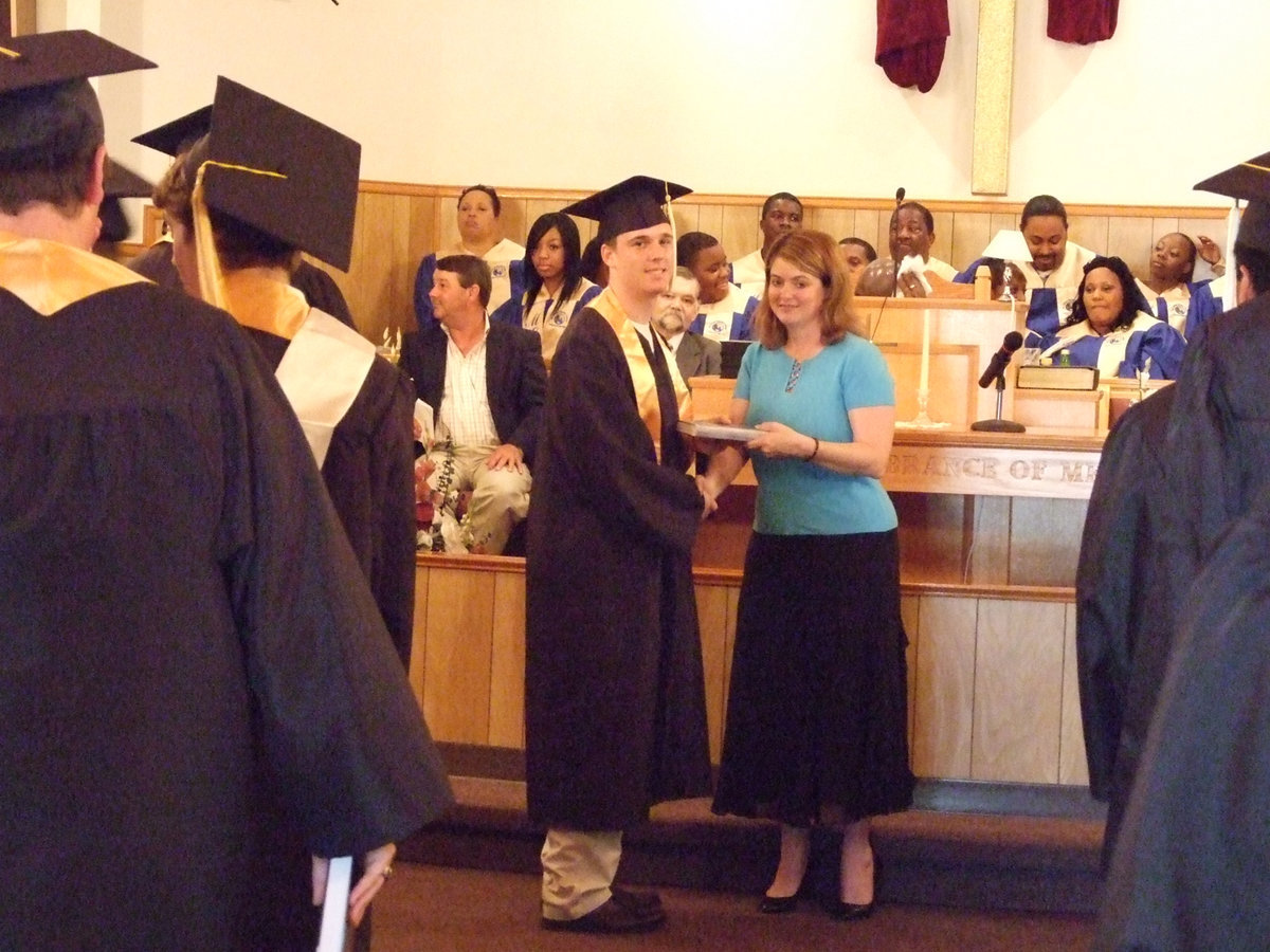 Image: Austin is back — Senior Austin Childers receives his bible from Ms. Parker.