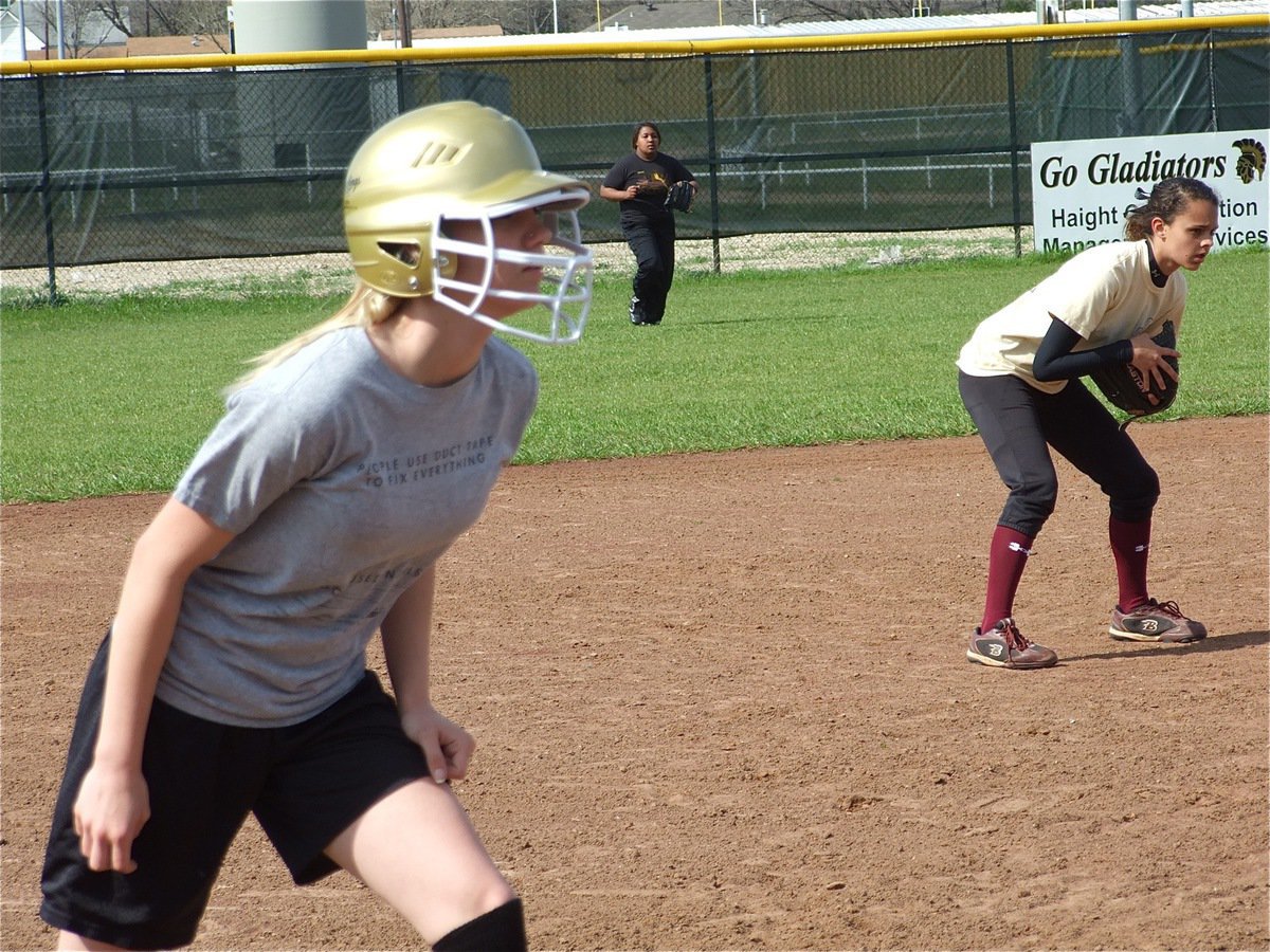 Image: Sierra’s on 3rd — Center fielder Khadijah Davis and shortstop Anna Viers try to keep Sierra Harris from scoring.