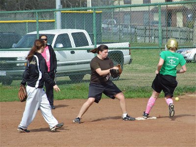 Image: Seniors combine — Drew Windham flips the ball to fellow senior, Cori Jeffords, for the out.
