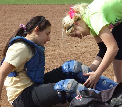 Image: Sis, help! — Megan Richards helps her little sister, Alyssa Richards, get dressed for her catching duties.