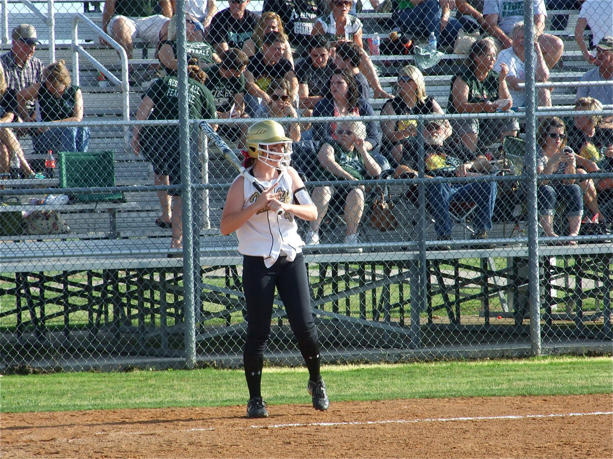 Image: Bumpus scans field — Bailey Bumpus checks her grip before stepping into the batter’s box.