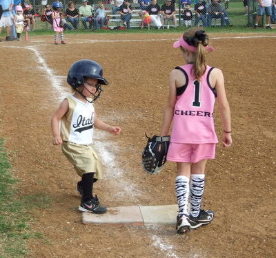 Image: Ella is safe! — After reaching first base, Ella Hudson has step one down.
