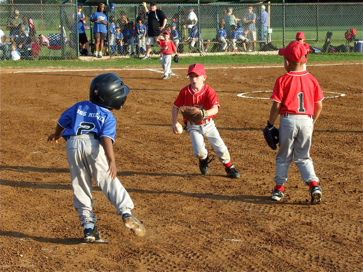 Image: The chase — Italy chases the Bulldog runner back to first base.