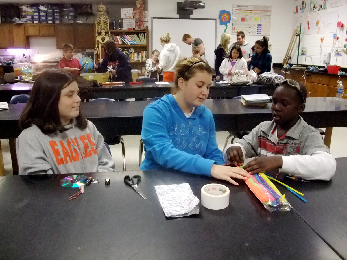 Image: More Leg Making — Brenna Murray, senior Elizabeth Watson and Terry Shears are starting to make the legs for the Jitterbug. Elizabeth said, “The kids learn a lot and they really enjoy it.”