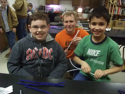 Image: We Are Twisting! — Corey Embry (4th grader), Alex Hernandez (4th grader) and Jacob Weaver (senior) are busy twisting pipe cleaners for the Jitterbug’s legs. Jacob said, “This program is pretty good. I have seen most of the students first grade up to the fifth grade and we have done all sorts of different projects.”