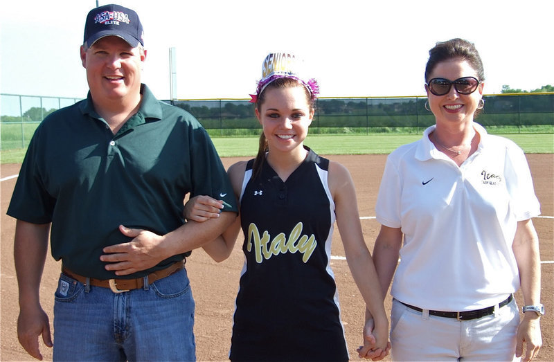 Image: All in the family — Graduating Senior Drew Windham holds her parents, Joe and Andi, close during her introduction on Senior Day. Joe is an umpire, by the way, and Andi is an assistant coach for the softball team and a teacher at Italy High School.