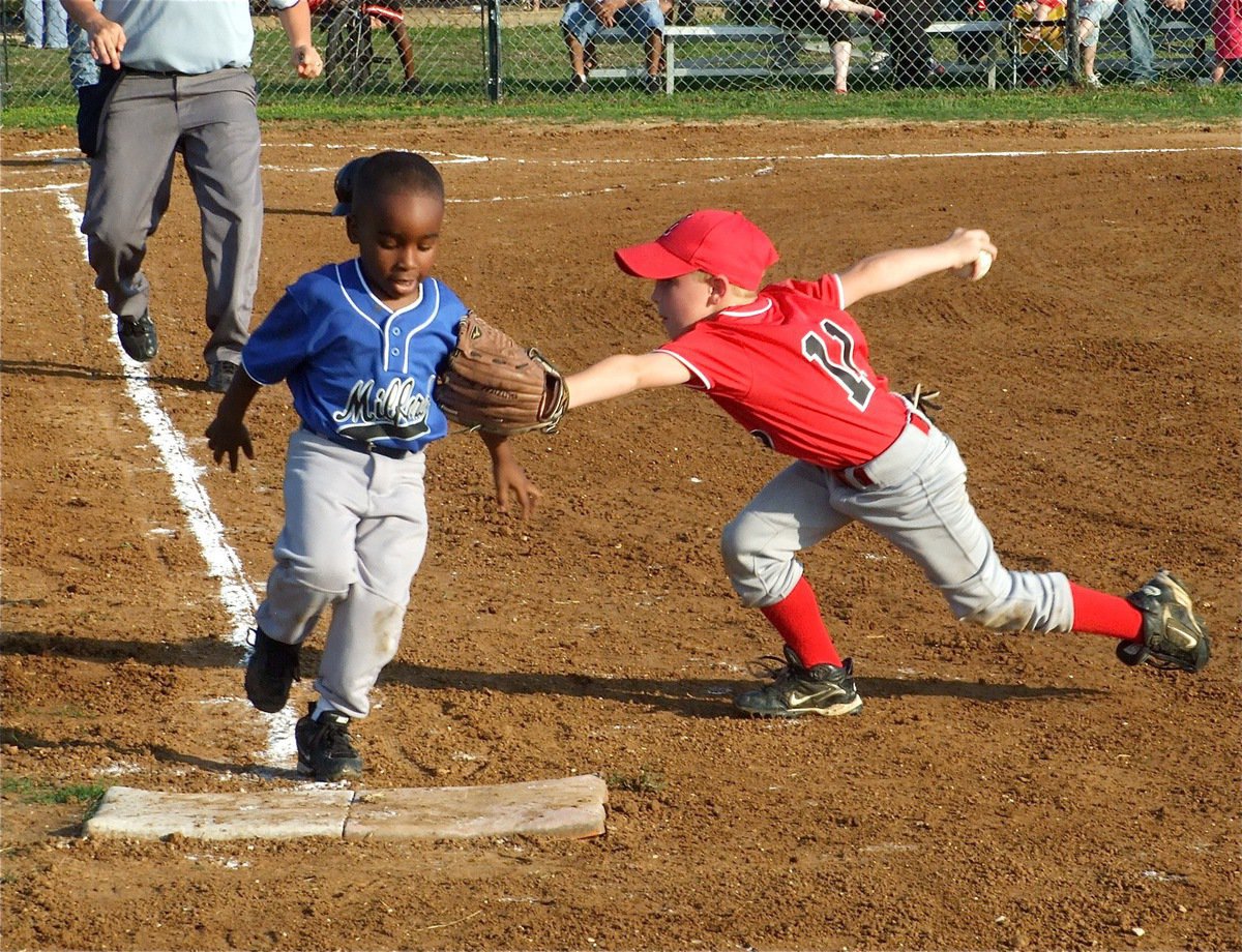 Image: Close play — Ty Cash tries for the tag at first base against Milford.