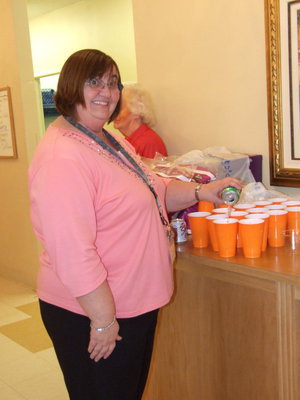 Image: Carolyn Powell Activities Director — Carolyn is busy pouring carbonated drinks and handing out goodies to the residents.