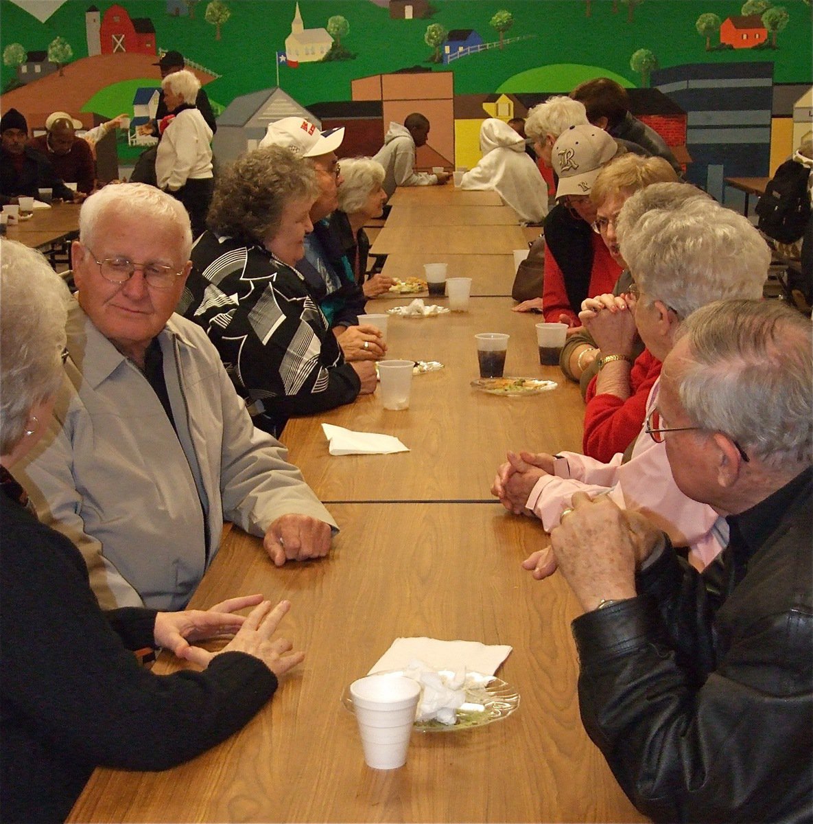 Image: Reminiscing — Honored players from the 1955 girls semi-finalist team and the 1974 boys regional finalist team mingled after the games inside the Italy High School cafeteria.