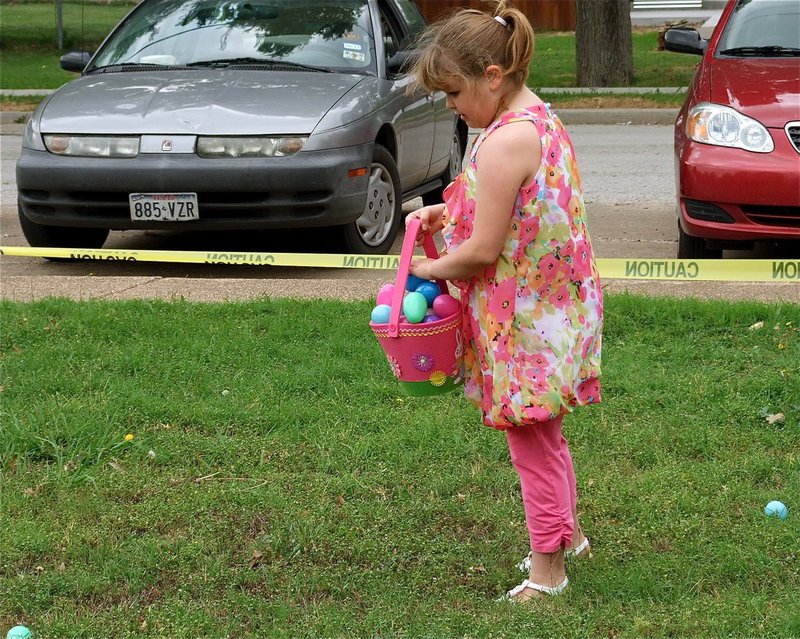 Image: Pretty in pink — Youngsters canvas the library’s front lawn for Easter eggs.