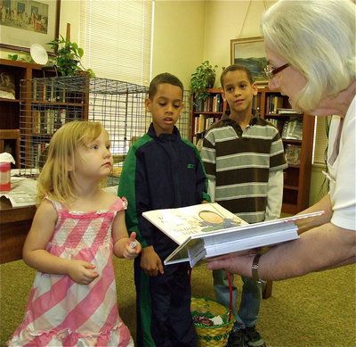 Image: Prize winners — Dunlap Memorial Libray trustee, Ann Byers, presents Azlin Itson, Kourtni Kimmons and Jacob Kimmons with their very own library books after each of these Easter Egg hunters found special prize filled eggs.