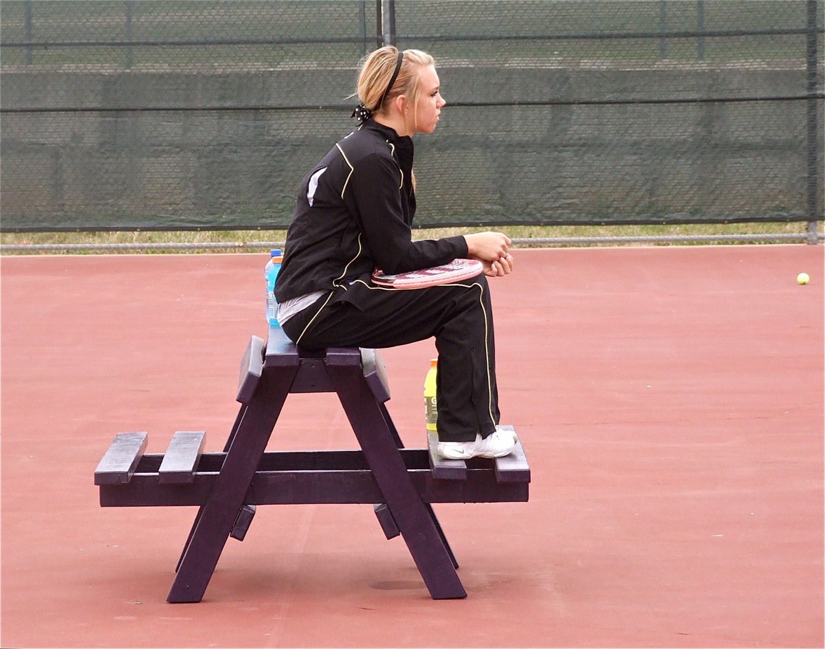 Image: Sitting in Alvarado — Sierra Harris watches her tennis teammates warming up.