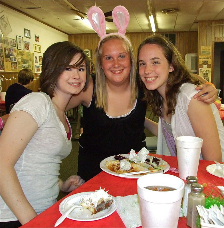 Image: Easter feast — Meagan Hooker, Drenda Burk and Melissa Smithey are all smiles after enjoying their spaghetti.
