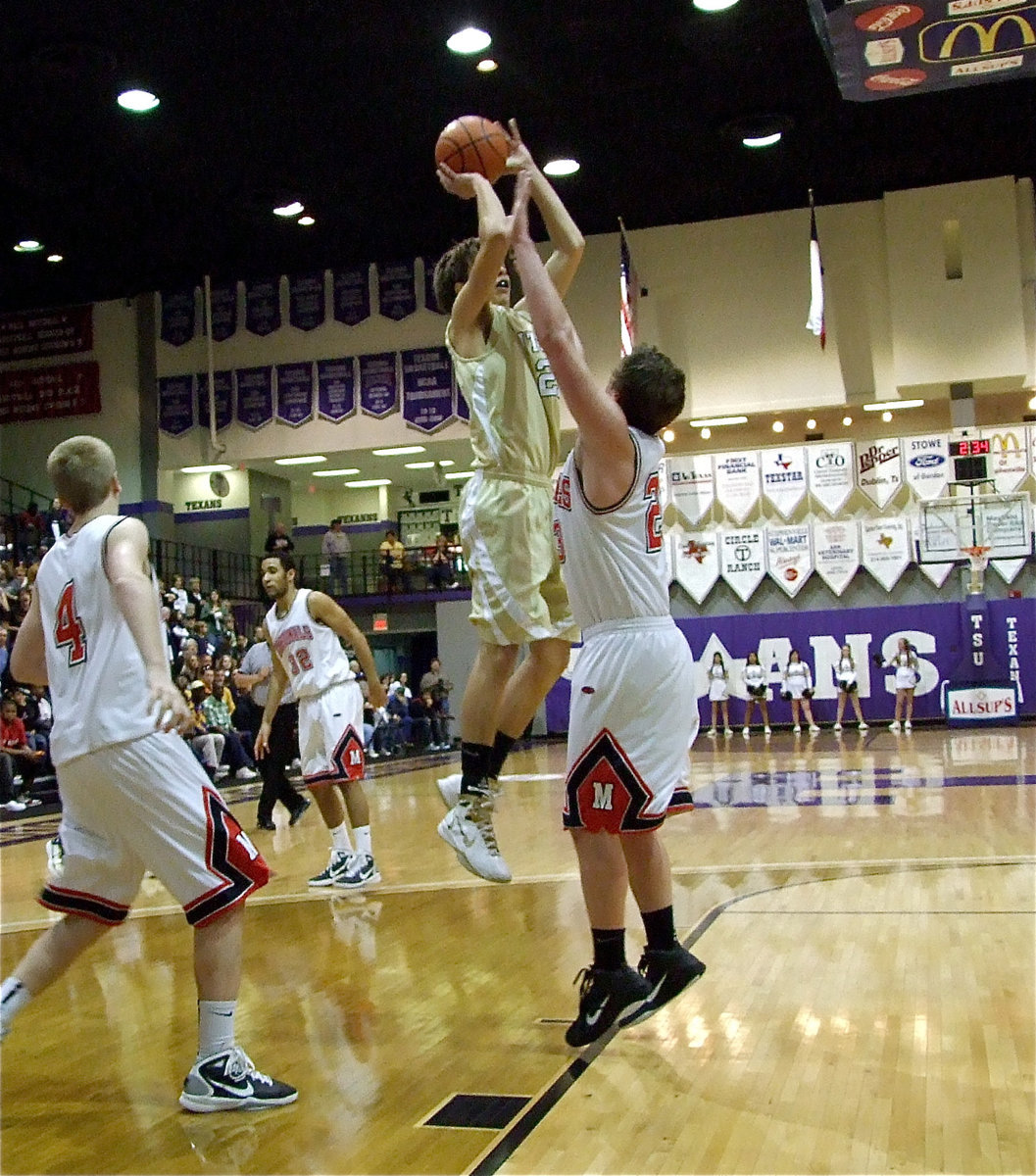 Image: Hopkins shoots — Cole Hopkins(21) tries to shake off a Cardinal defender.