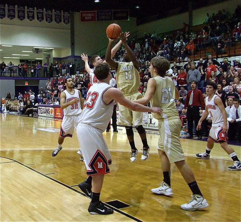 Image: Jasenio takes jumper — Jasenio Anderson(11) goes up for a guick shot with teammate Cole Hopkins(21) on the block.