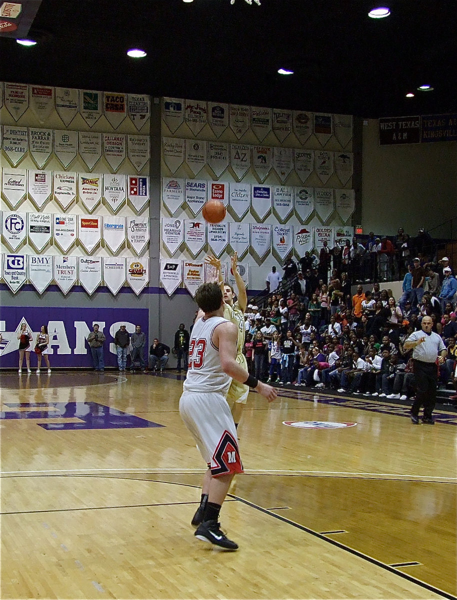 Image: Face! — Ryan Ashcraft(4) knocks down a three-pointer early in the third-quarter with Melissa’s Hondo Webb(23) defending.