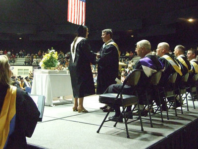 Image: Angelica shakes Larry’s hand — Angelica Garza receives her diploma from board member, Larry Eubank.